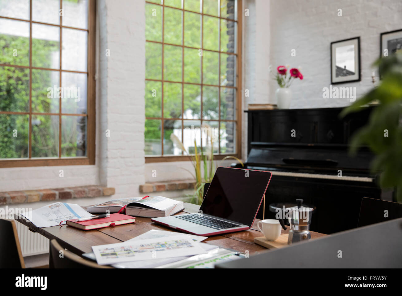 Home office con piano in background in confortevole appartamento loft Foto Stock