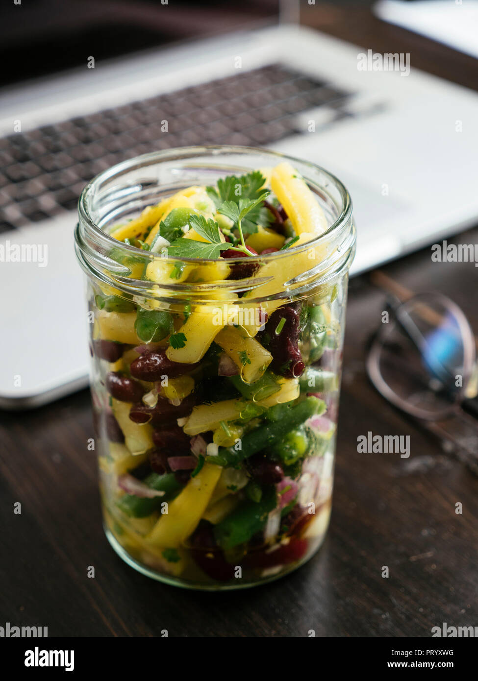 Vasetto di tre insalata di fagioli sulla scrivania in ufficio Foto Stock