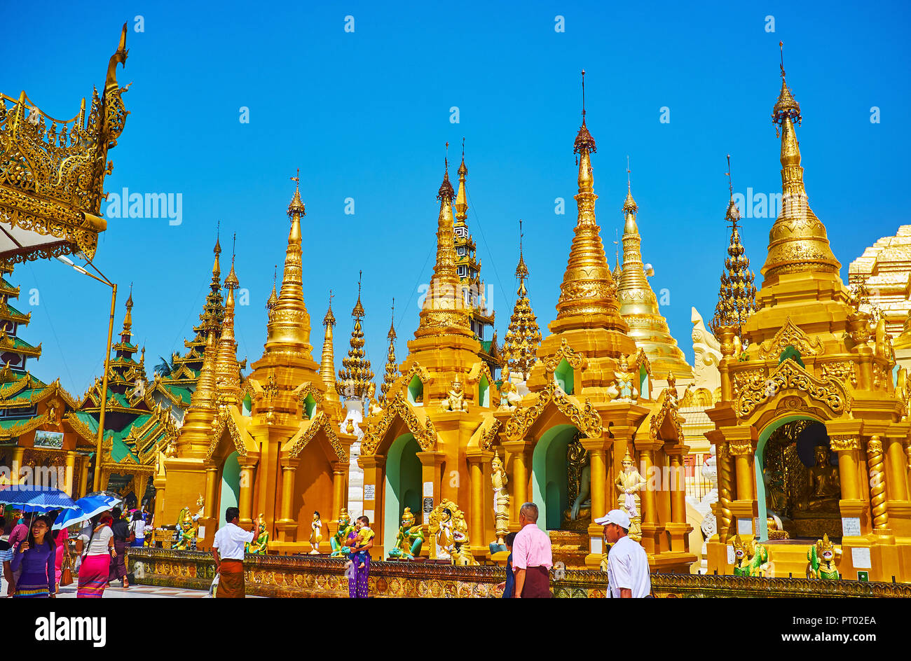 YANGON, MYANMAR - 27 febbraio 2018: Il buddista pellegrini a piedi lungo la linea esterna stupa dorato di Shwedagon pagoda, il 27 febbraio di Yangon Foto Stock