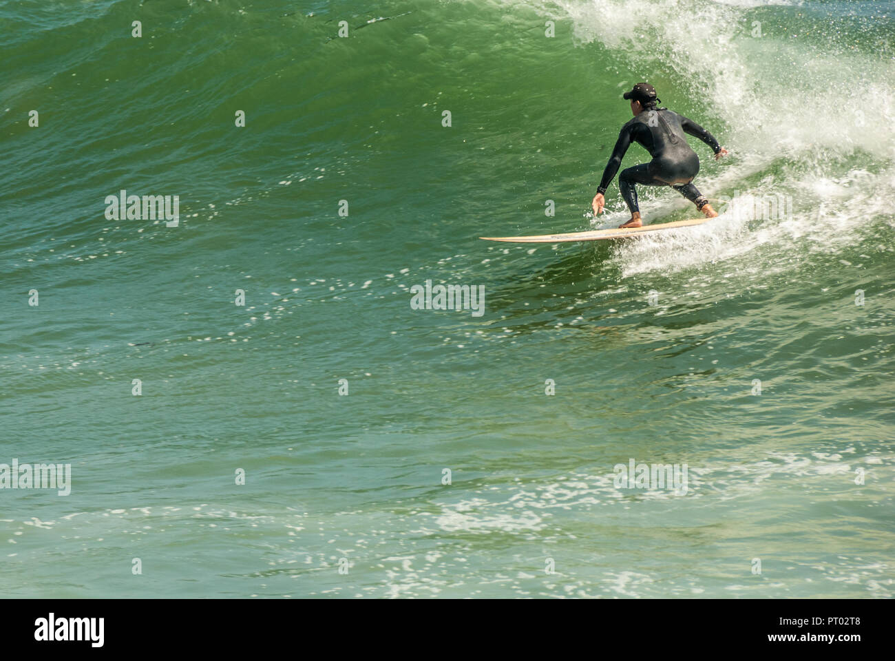 Surfer a cavallo di un punto grande onda di rottura al tramonto il punto in Pacific Palisades, la Contea di Los Angeles, California. (USA) Foto Stock