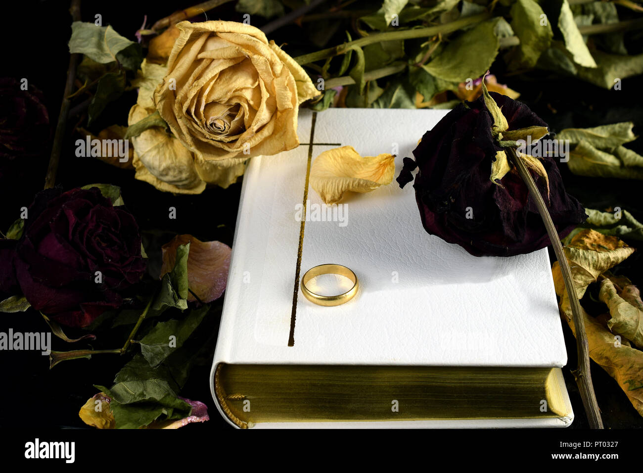 White Sacra Bibbia, un anello di nozze e asciugare le rose. Toccare Immagine concettuale di matrimonio e di morte e "fino alla morte fare parte di noi' voto di nozze. Foto Stock