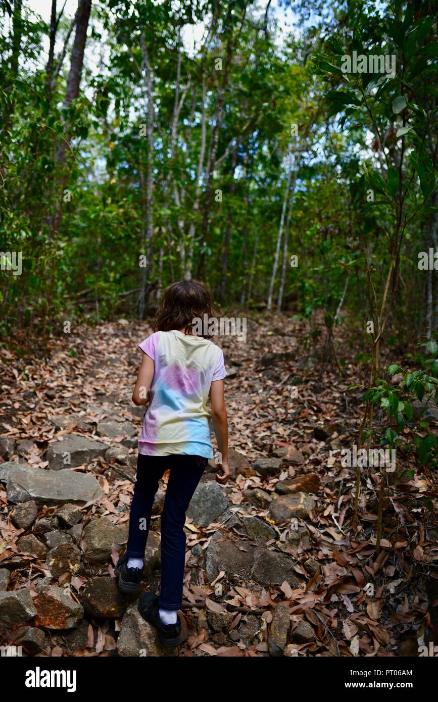 Un bambino che indossa un colorato di t-shirt a piedi attraverso una foresta, Dalrymple gap, QLD, Australia Foto Stock