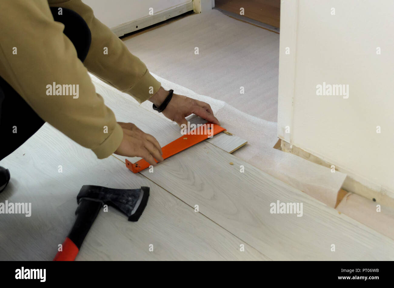 Ristrutturazione di un appartamento, l'uomo la posa di pavimenti in laminato in camera. Foto Stock