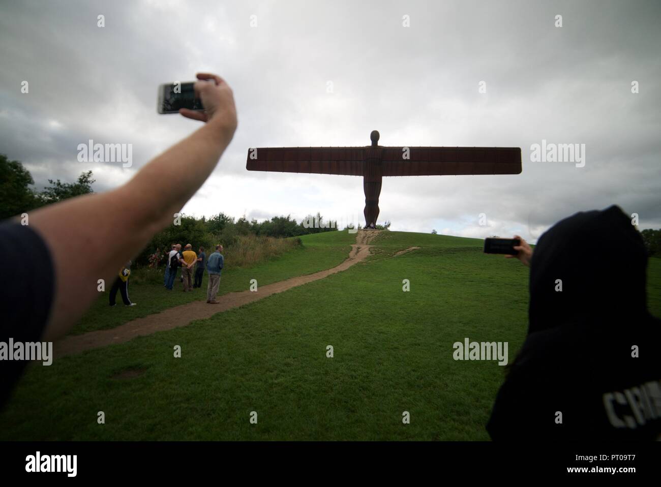 I turisti per scattare delle foto di un angelo del Nord statua in Tyne and Wear utilizzando i loro telefoni cellulari (iPhone) Foto Stock