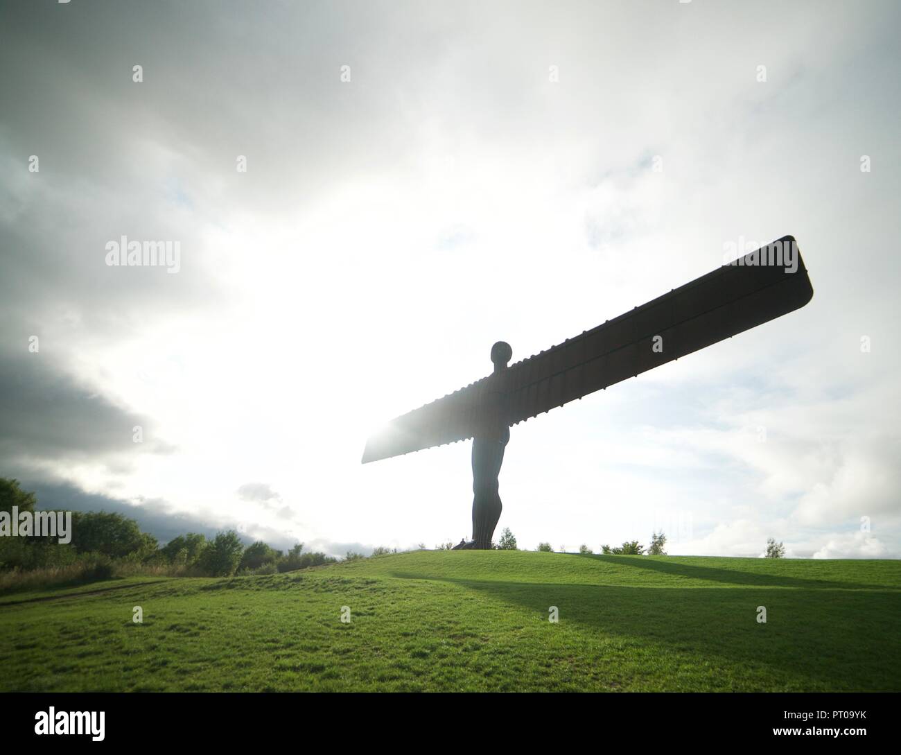 La famosa e Angelo iconica della scultura del Nord, situata a Gateshead, Tyne and Wear, Inghilterra, ha vinto una luminosa giornata di sole con il sole che splende dietro. Foto Stock