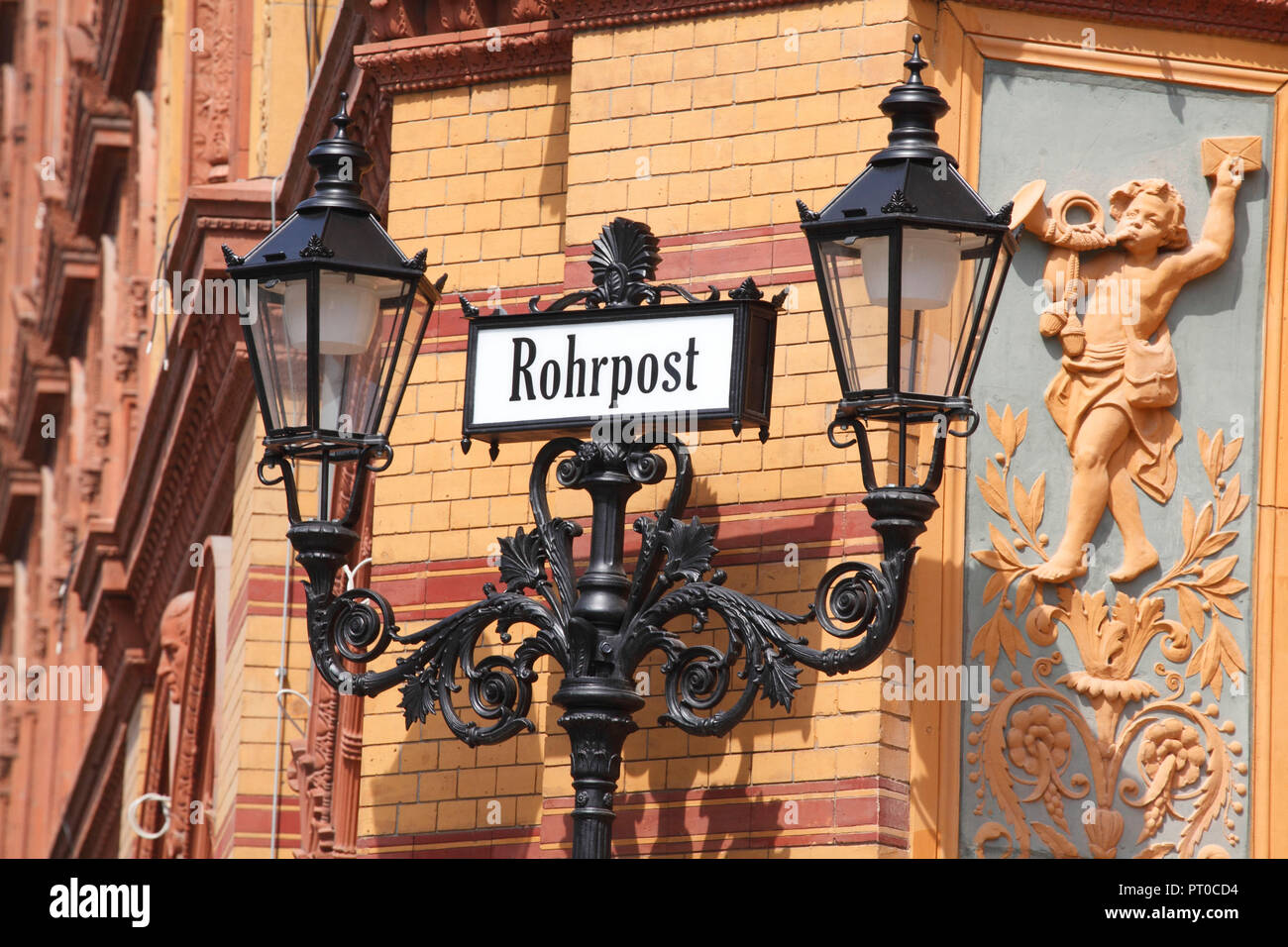 Il vecchio segno "Rohrpost' con la vecchia strada lampada all'ex Postfuhramt in Oranienburger Straße, Berlino, Germania, Europa Foto Stock