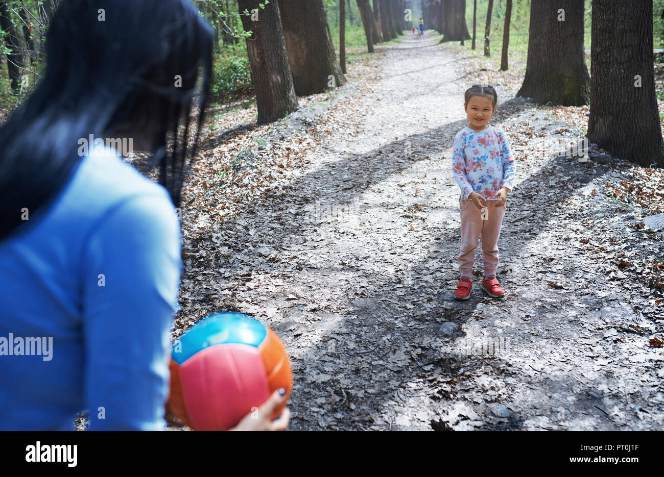 Madre e figlia giocare a palla in un parco Foto Stock