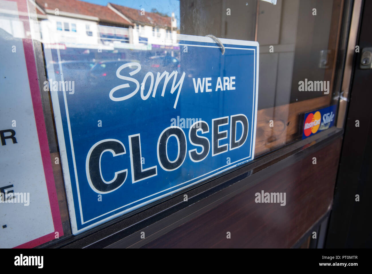 Un ci dispiace non sono segno di chiusura in una vetrina di un negozio che riflette un giro di affari verso il basso o il fallimento o di recessione Foto Stock