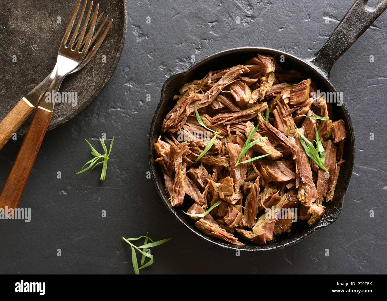 Carne bovina italiana per i panini in padella sulla pietra nera dello sfondo. Vista superiore, laici piatta Foto Stock