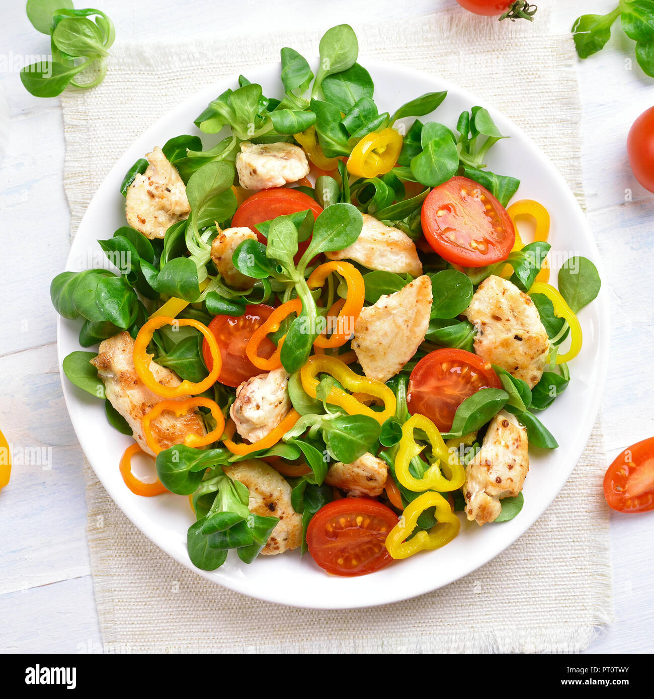 Una gustosa insalata di pollo con verdure fresche su bianco tavolo in legno.Vista Superiore Foto Stock