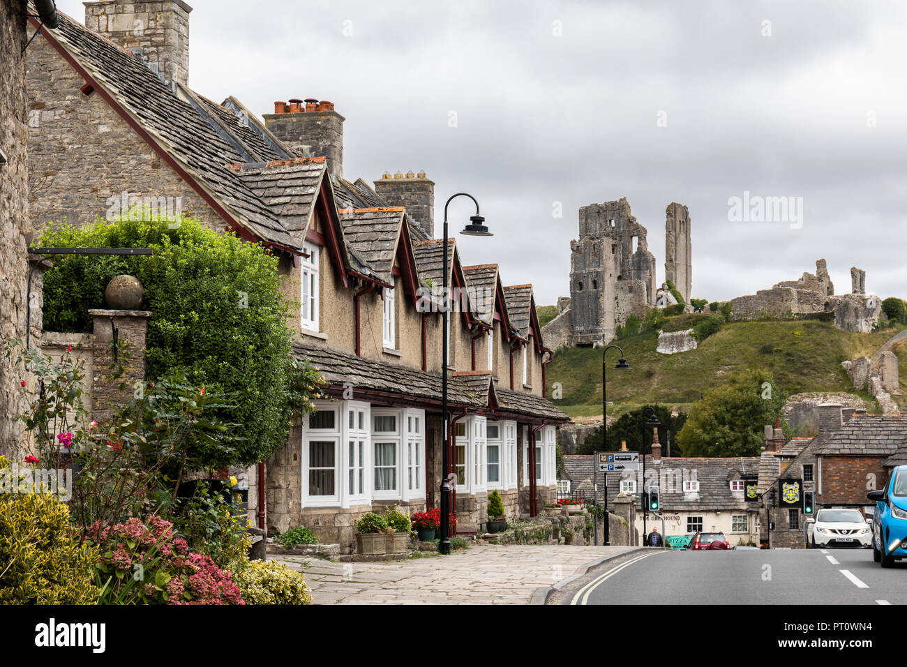 Corfe Castle si affaccia sulle pittoresche case del villaggio, Corfe Castle, Wareham, Dorset, Inghilterra, Regno Unito Foto Stock