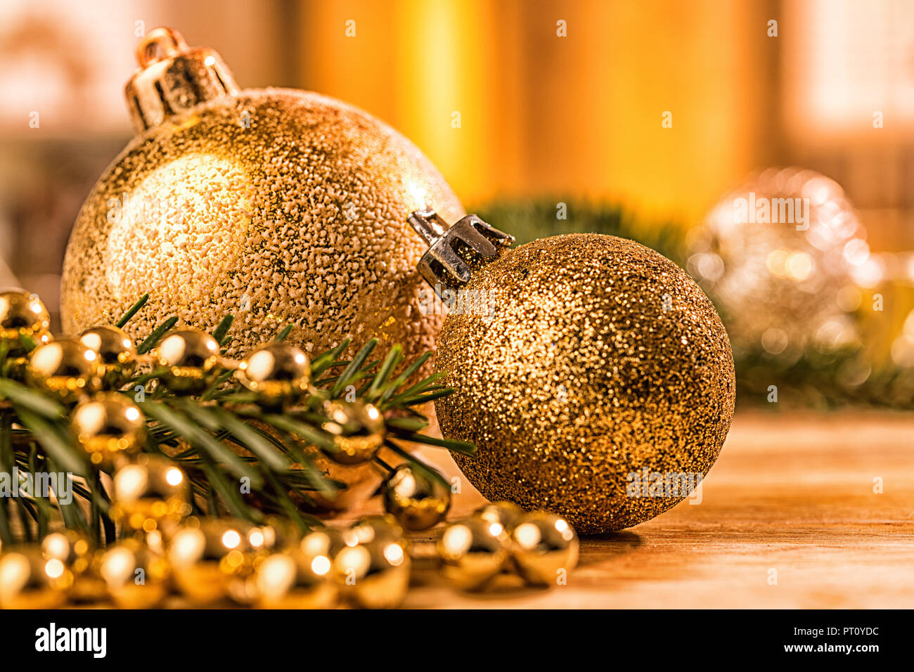 Goldene christbaumkugel mit Tannenzweig, Kerze, Lichter und Deko Foto Stock