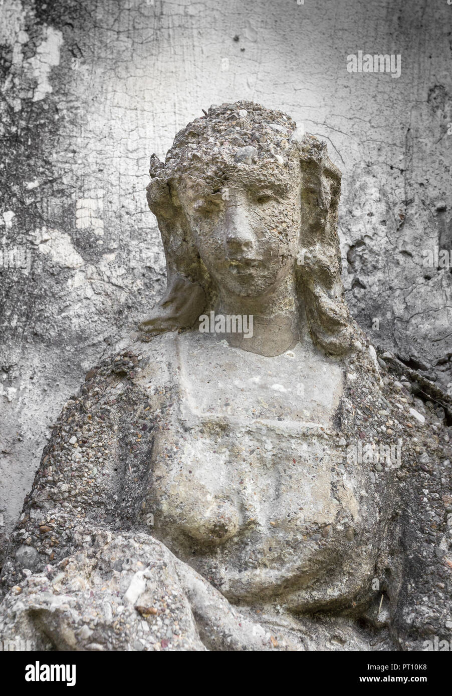 Antica statua di una donna con una espressione triste. Su uno sfondo grigio e parete ruvida. Ideale per i concetti e gli sfondi. Foto Stock