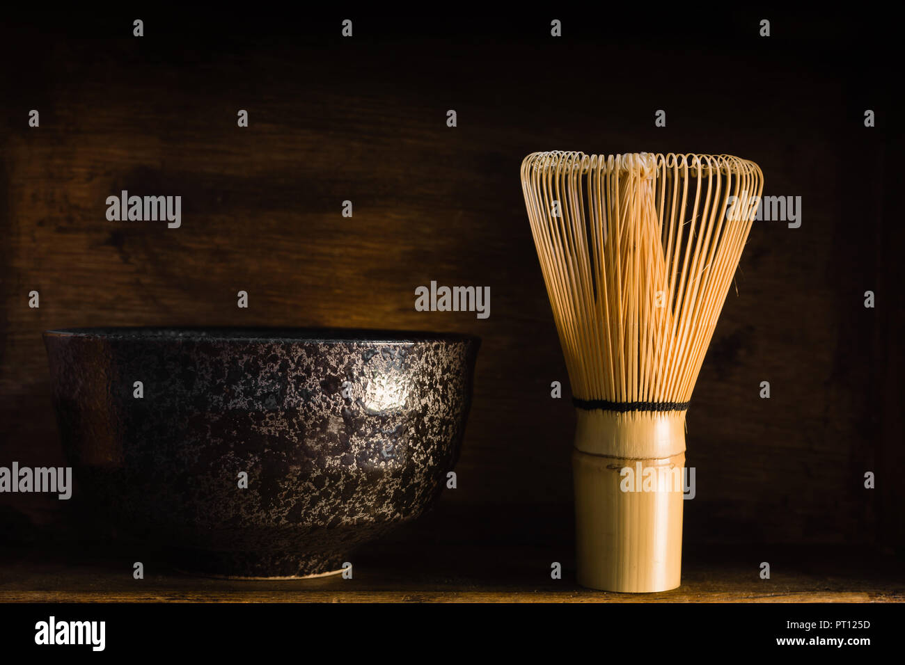 Giapponese di tè verde Matcha frullino o chasen con un chawan o tradizionale recipiente di ceramica shot con scuri di illuminazione creativa Foto Stock