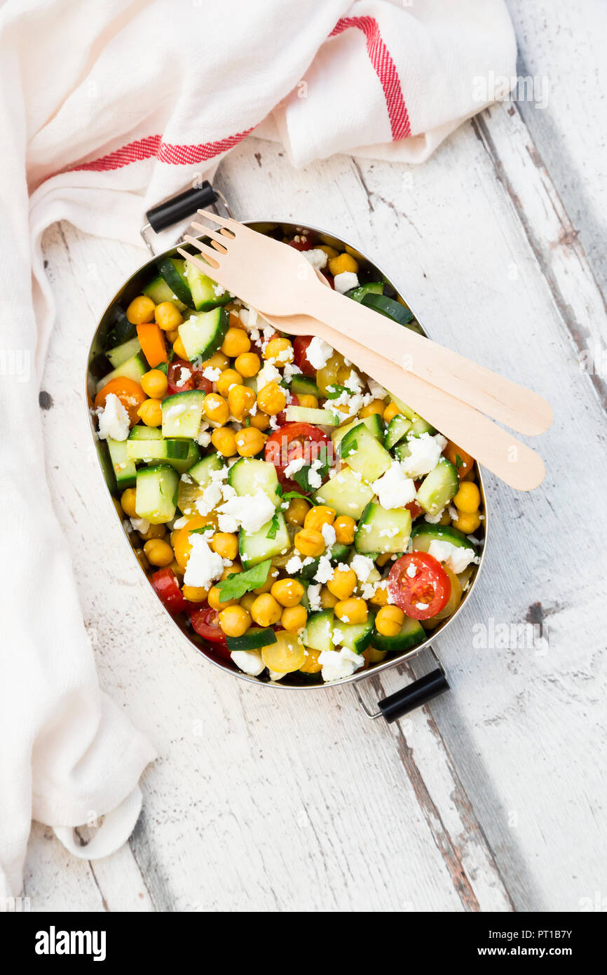 Scatola di pranzo di insalata con ceci arrosto con curcuma, feta, cetriolo, pomodori e prezzemolo Foto Stock