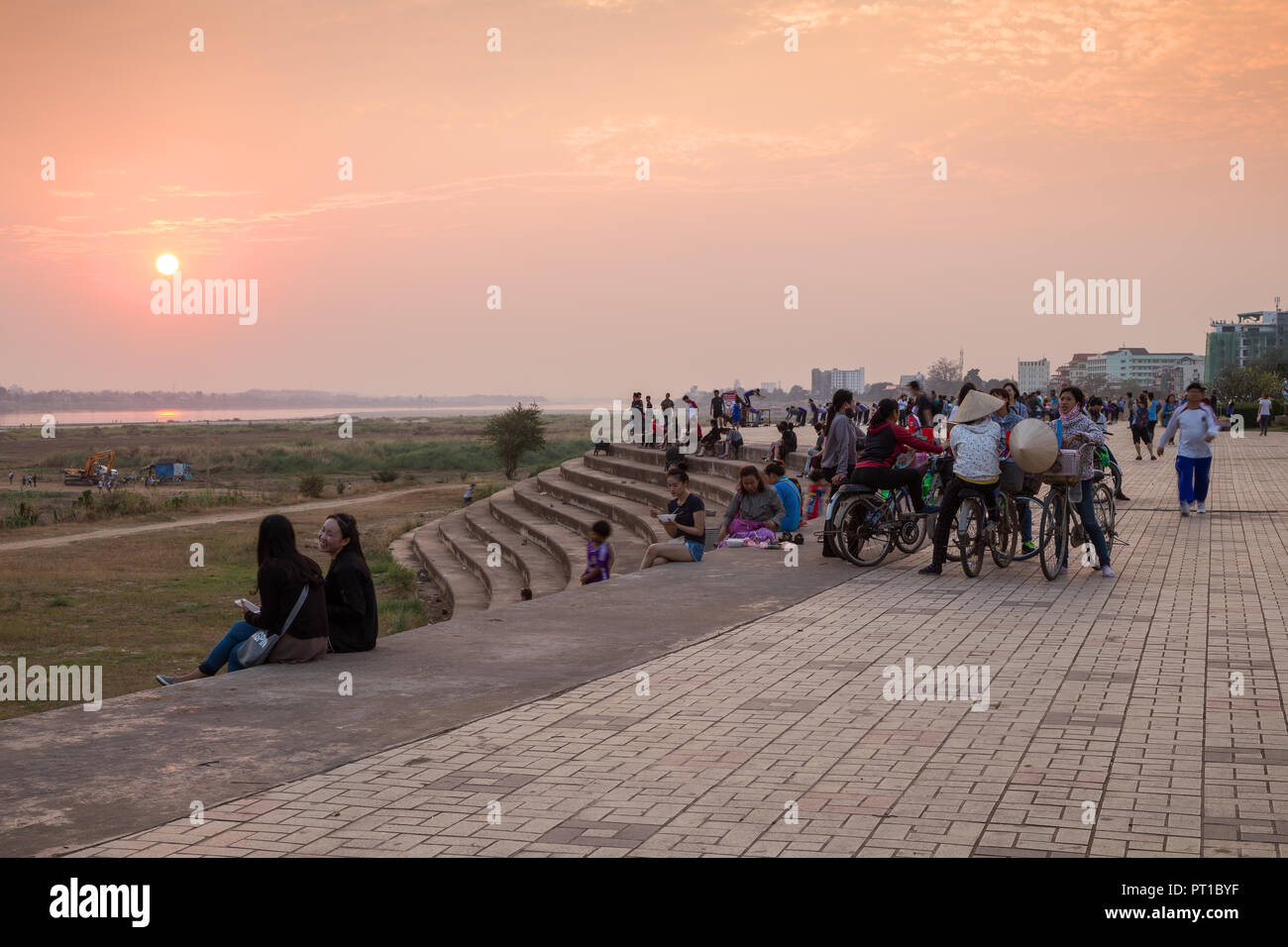 Turisti e gente locale e seduta rilassante presso il famoso Mekong Riverside Park di Vientiane, Laos, al tramonto. Foto Stock