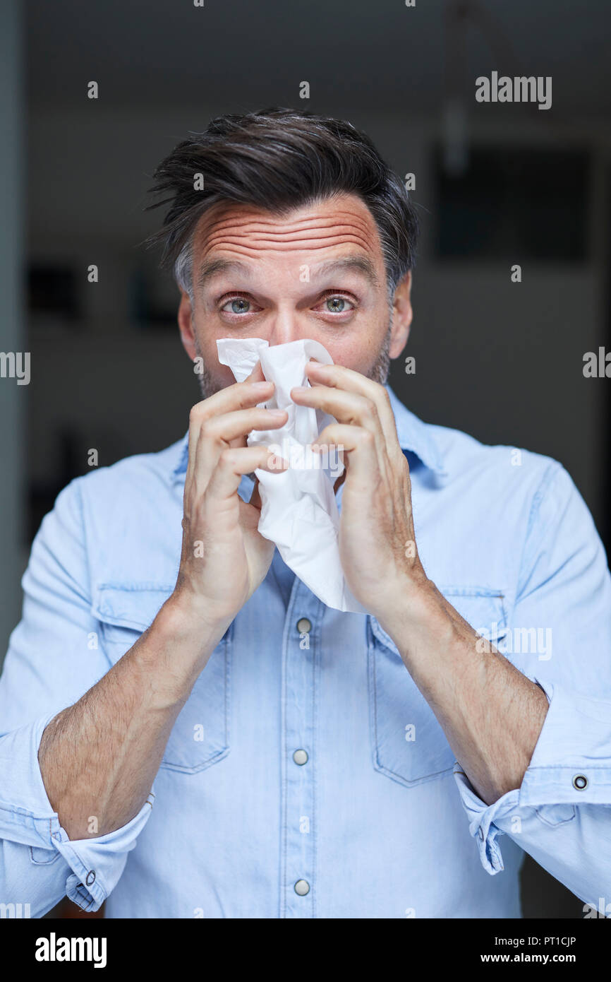 Ritratto di uomo soffia il naso Foto Stock