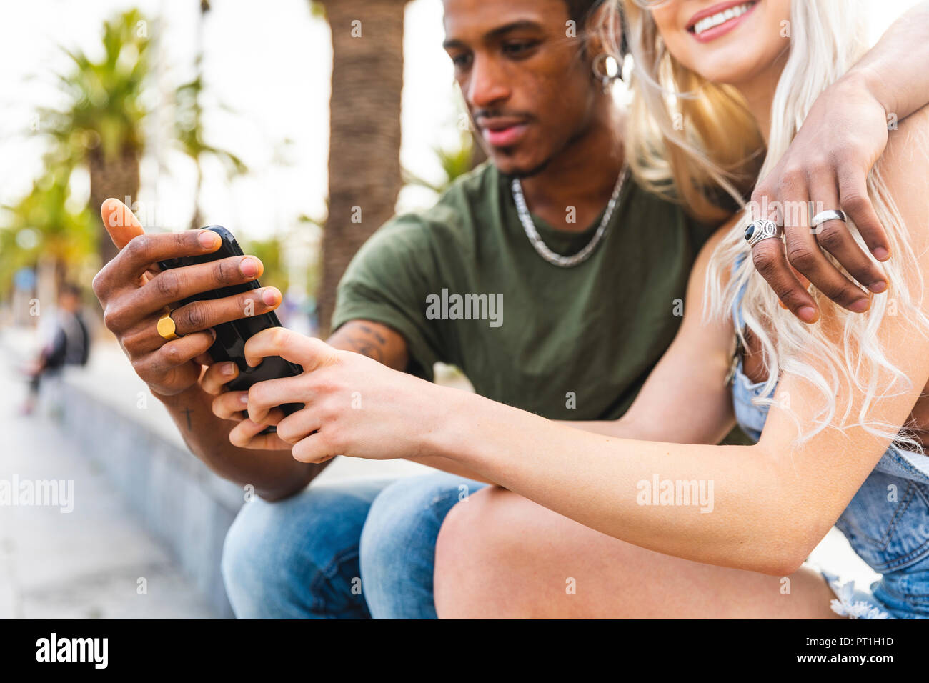 Mani di multiculturale di coppia giovane azienda smartphone Foto Stock