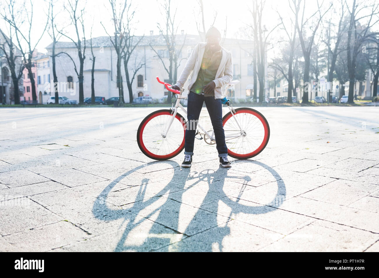 Giovane Azienda sulla bicicletta squre urbana Foto Stock