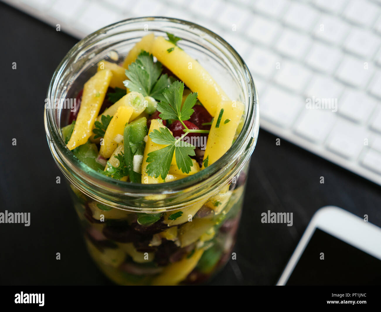 Vasetto di tre insalata di fagioli sulla scrivania in ufficio Foto Stock