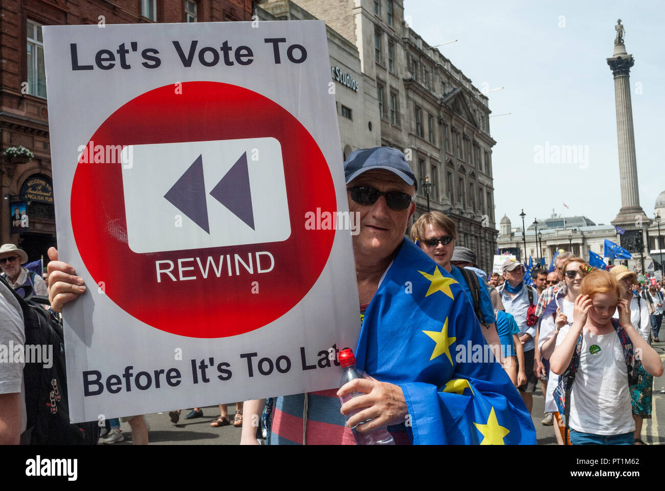 Uomo su anti- Brexit rally che trasportano grandi poster "votazione consente di riavvolgere prima che sia troppo tardi" con grandi "wind" logo. Rally in background. Foto Stock