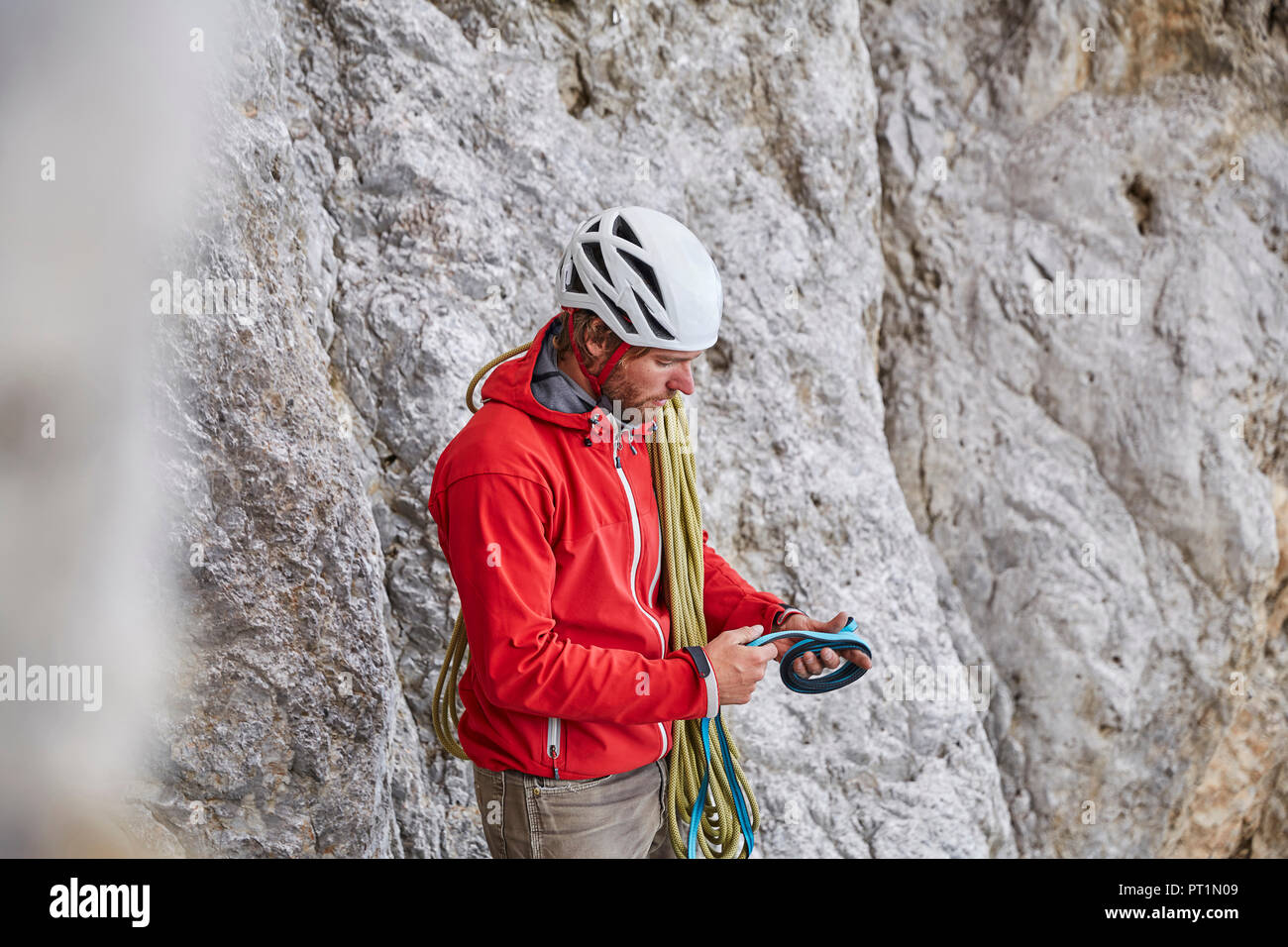 Uomo con corda e arrampicata attrezzature Foto Stock