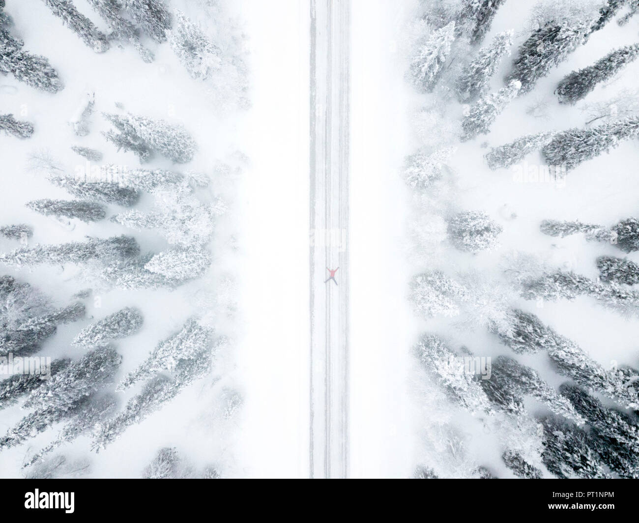 Vista aerea della persona sdraiata su strada nella foresta di ghiaccio, Pallas-Yllastunturi National Park, Muonio, Lapponia, Finlandia Foto Stock