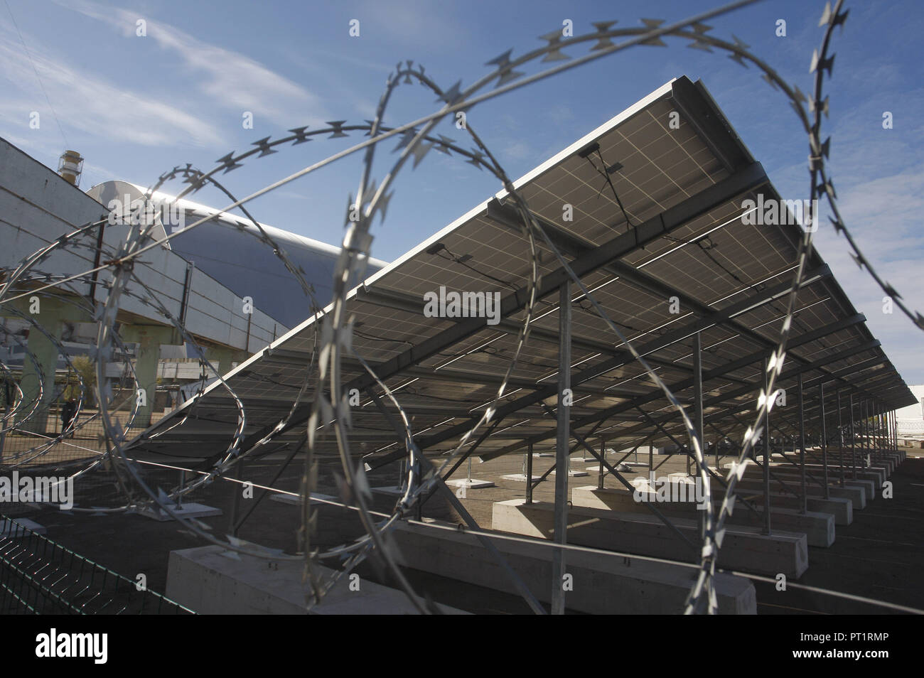 Kiev, Ucraina. 5 Ottobre, 2018. Una vista generale del primo e del mondo solo solar power plant 'Solar Chernobyl' di fronte alla quarta potenza nucleare blocco durante una cerimonia di apertura sul territorio della centrale nucleare di Cernobyl nel pripjat, Ucraina, 05 ottobre 2018. 'Solar Chernobyl' è un progetto congiunto di Rodina '"' Enerparc AG consorzio fondato nel 2013. L obiettivo del progetto è di attuazione dei progetti nel settore delle energie rinnovabili nelle zone che sono state distrutte dalla catastrofe di Chernobyl.Solar Cernobyl con una capacità di 1 MW è situato sul sito industriale della centrale di Cernobil Foto Stock