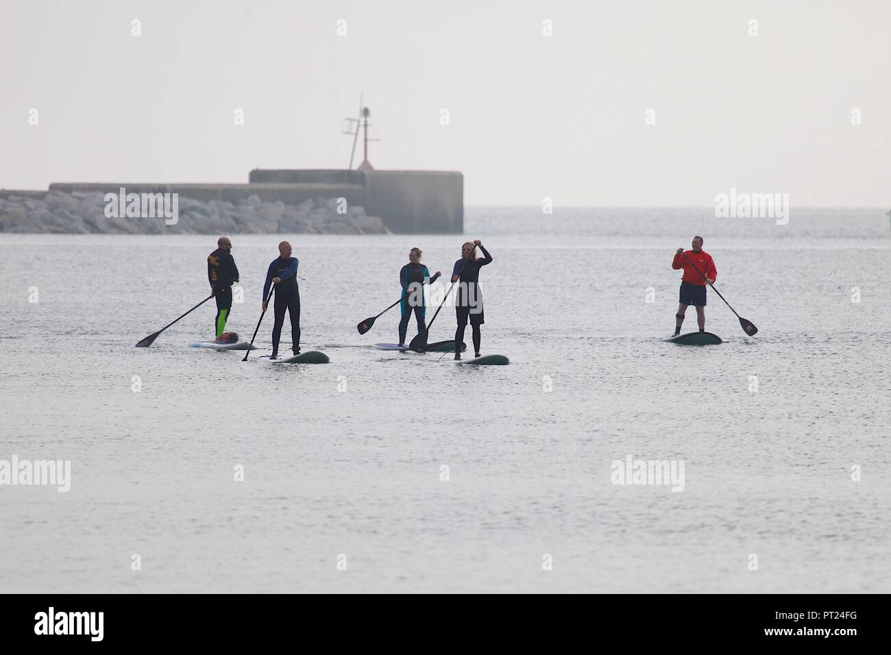 Hastings, East Sussex, Regno Unito. 6 Ottobre, 2018. Regno Unito Meteo: un gruppo di paddle boarder far meglio del nuvoloso meteo in Hastings come andare oltre il braccio del porto. © Paul Lawrenson 2018, Photo credit: Paolo Lawrenson/ Alamy Live News Foto Stock