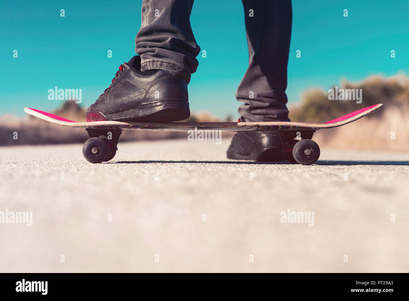 Pattinatore in piedi su skateboard Foto Stock