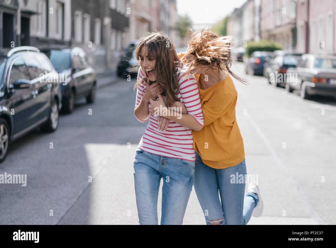 Due amiche al divertimento in città, in esecuzione Foto Stock