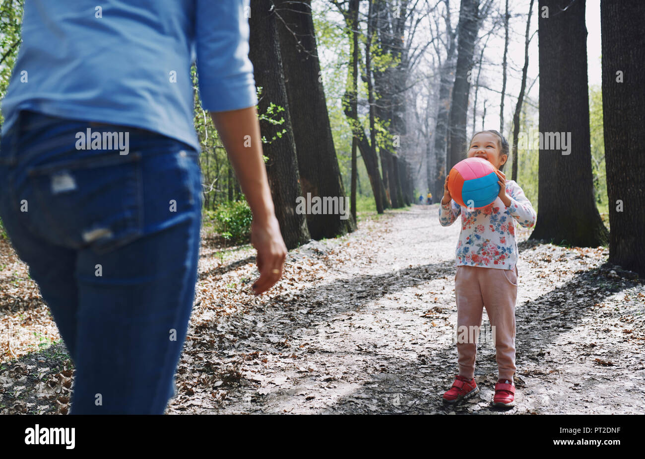 Madre e figlia giocare a palla in un parco Foto Stock