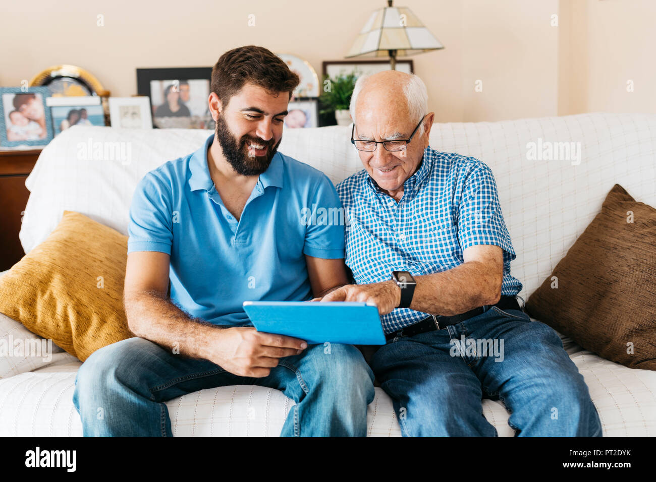 Nipote di adulti insegnamento il nonno di utilizzare tablet Foto Stock