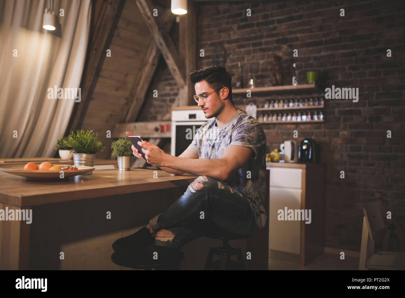 Giovane uomo utilizzando tablet in cucina a casa Foto Stock