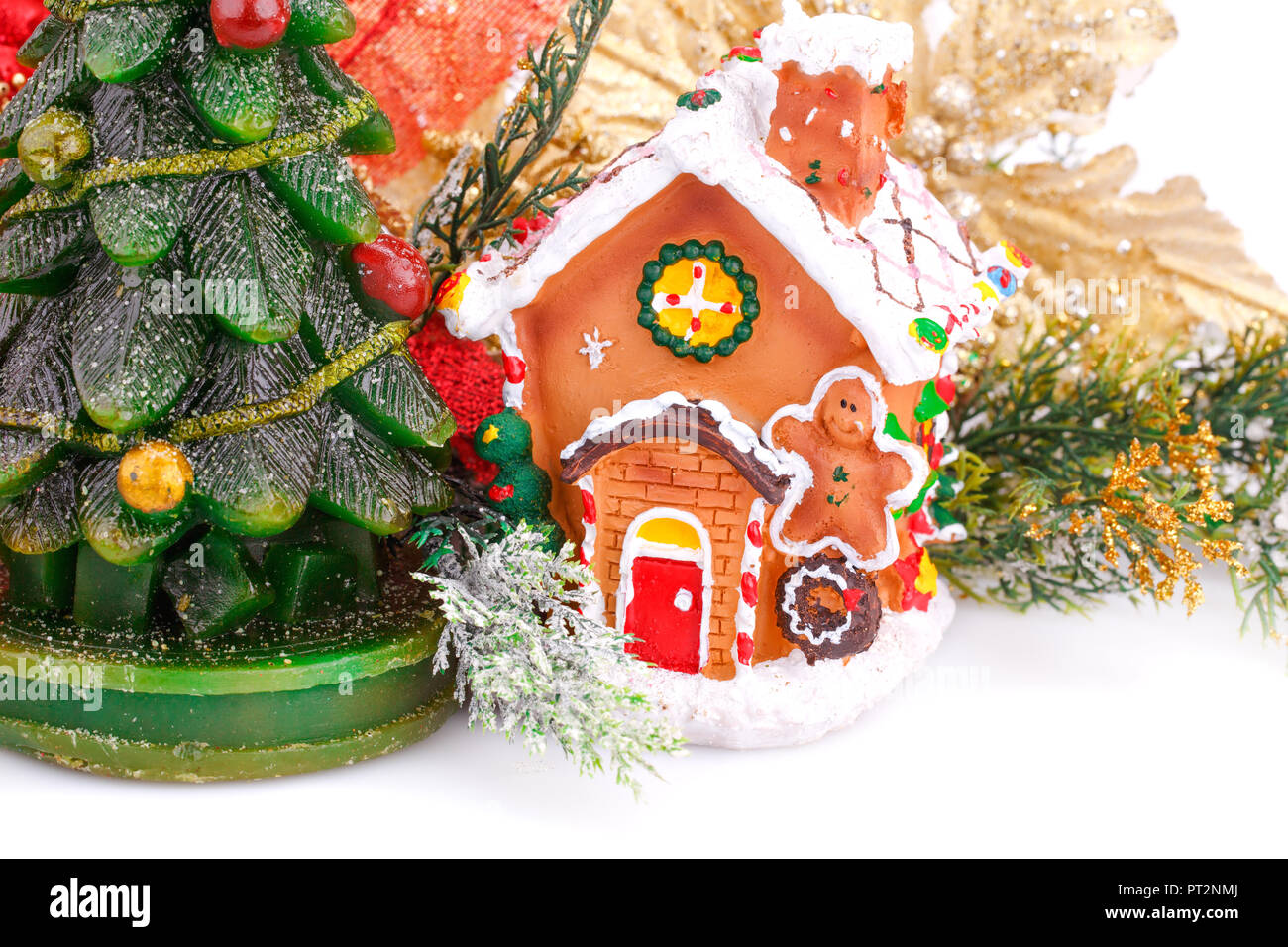 Abete candela, casa giocattolo e holly berry fiore su sfondo bianco. Foto Stock