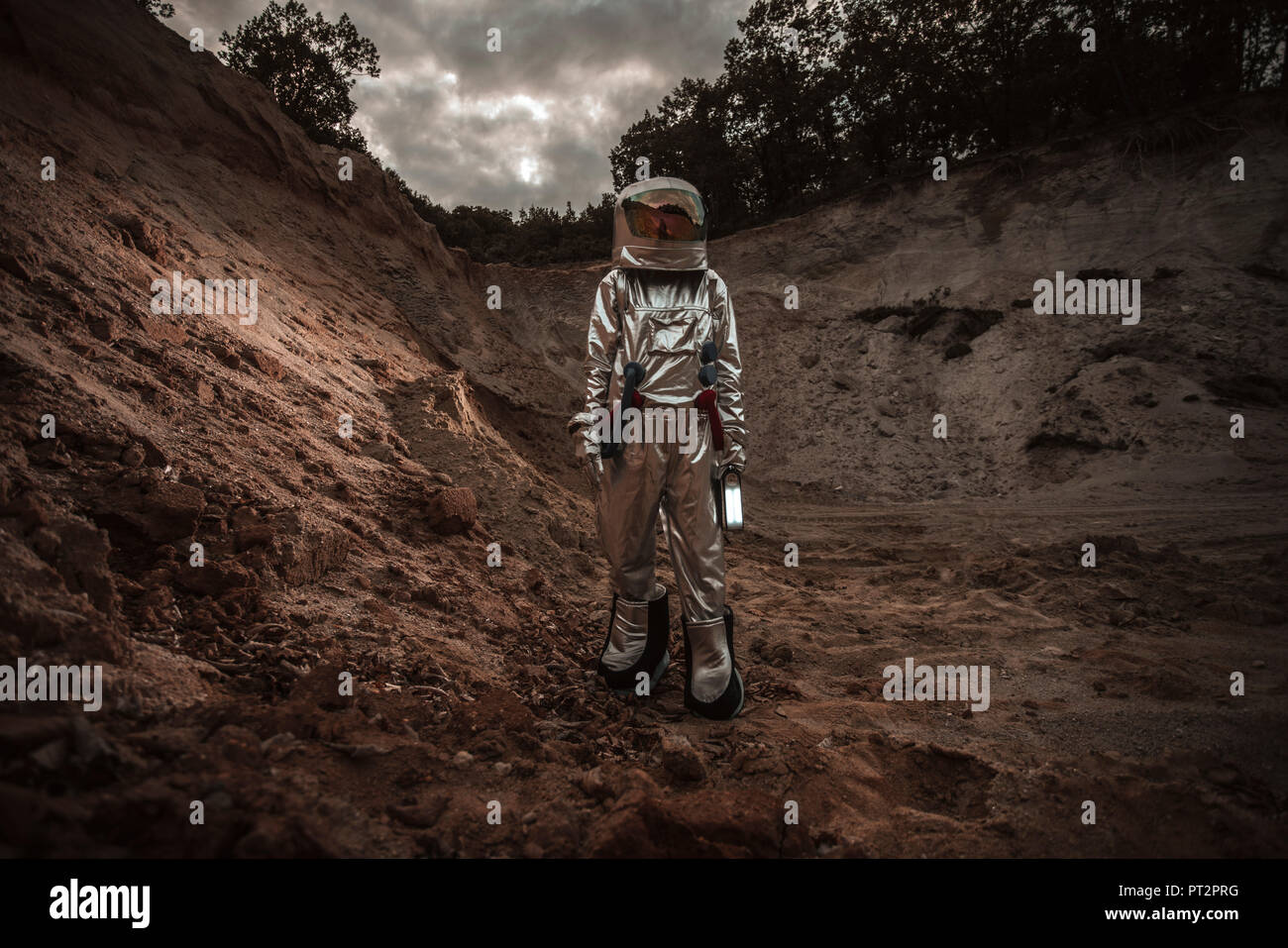 Spaceman esplorando il pianeta anonimi, tenendo in mano la torcia Foto Stock