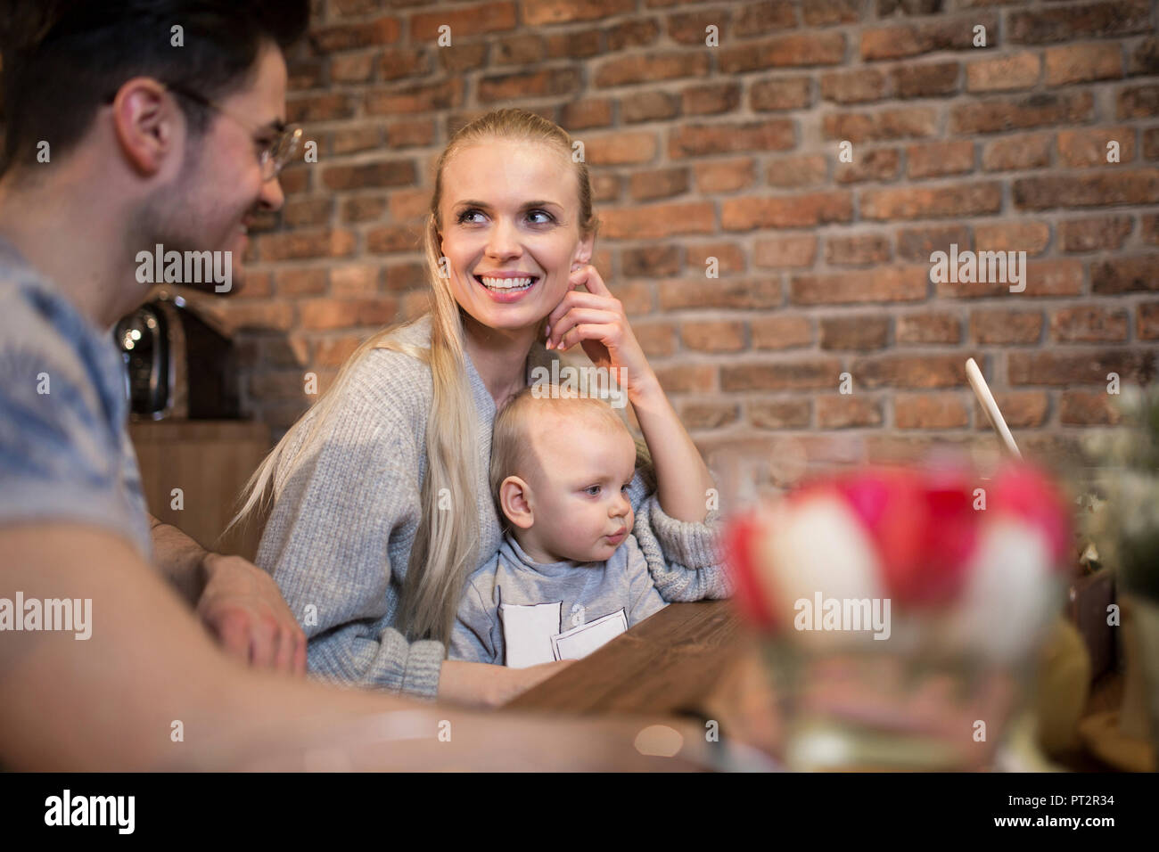 Felice giovani genitori di trascorrere del tempo in cucina a casa con la loro bambina Foto Stock