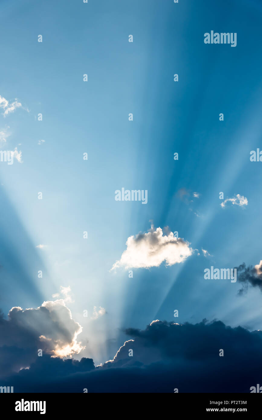 Un sunbeam guarda fuori da dietro le nuvole in un giorno di estate Foto Stock