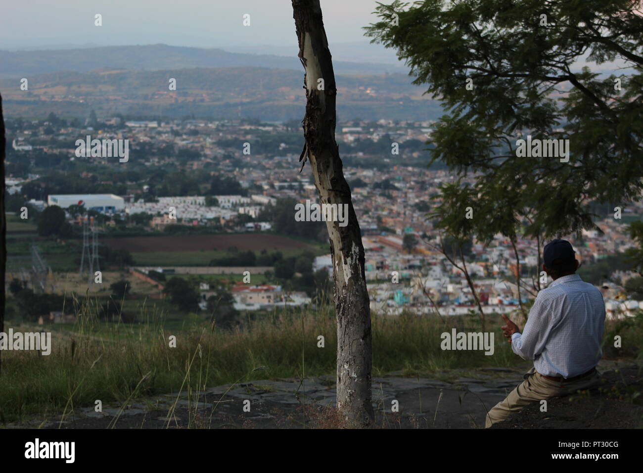 Señor apreciando el paisaje desde el Cerro de la reina en Tonala, vista panoramica de la barranca de Huentitan en onu atardecer de la ciudad Foto Stock