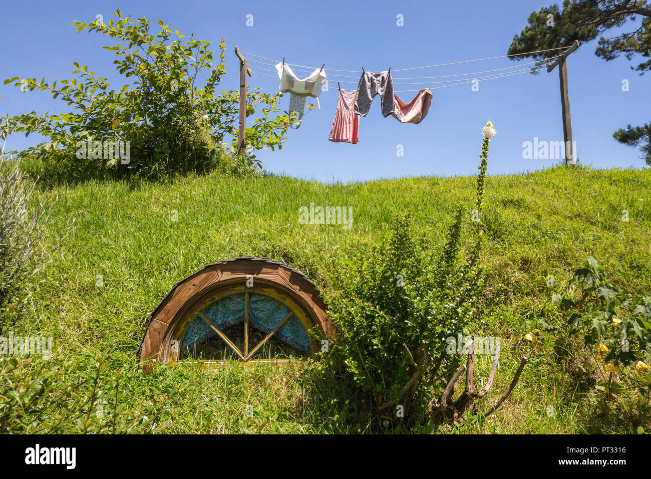 Panni stesi sulla linea di lavaggio sulla parte superiore di una casa Hobbot, Hobbiton Movie set, Matamata, regione di Waikato, Isola del nord, Nuova Zelanda, Foto Stock