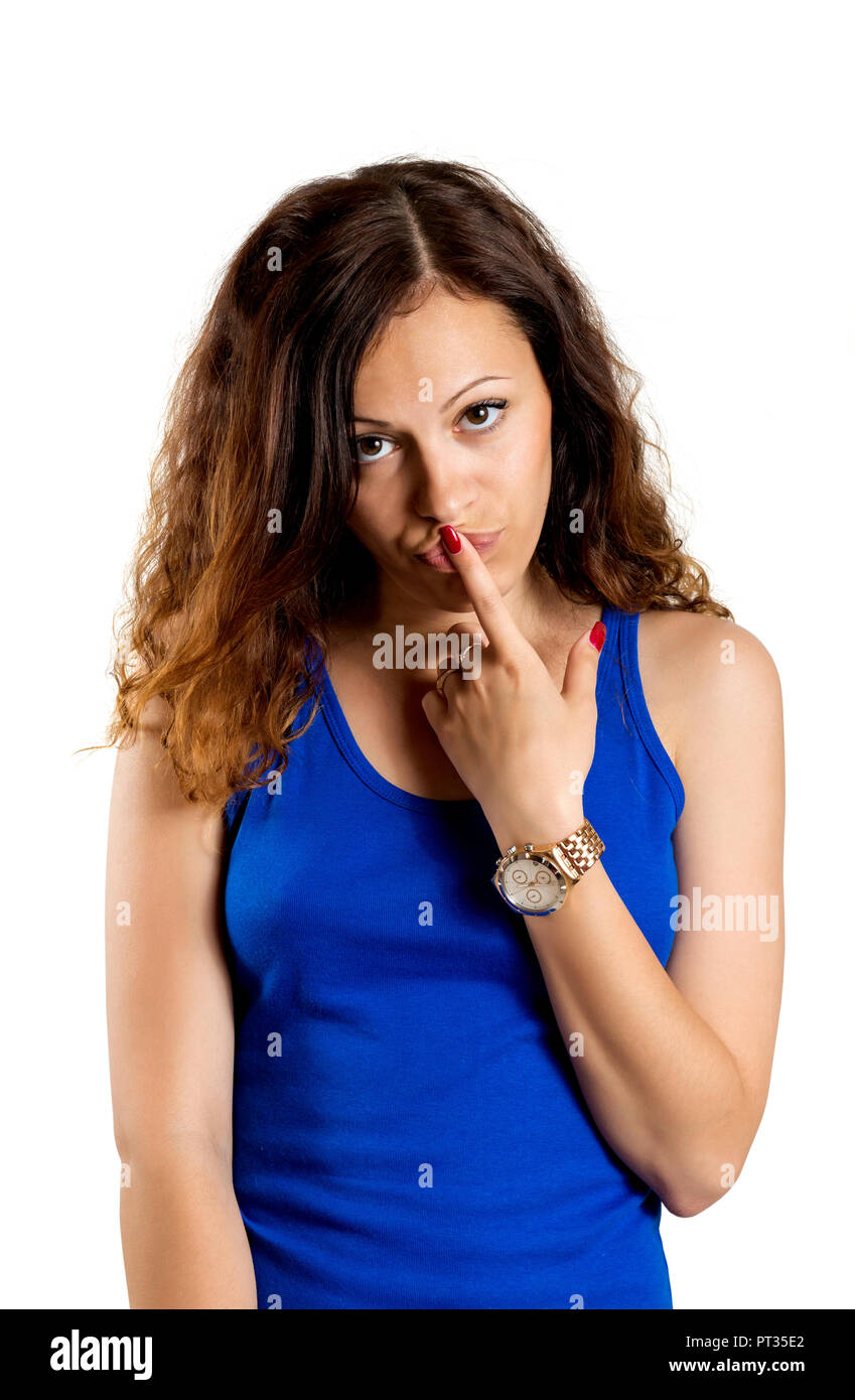 Bella donna con segno di silenzio isolato su sfondo bianco. Closeup ritratto di donna moderna seria con capelli lunghi tenendo il dito vicino alle labbra rosa Foto Stock
