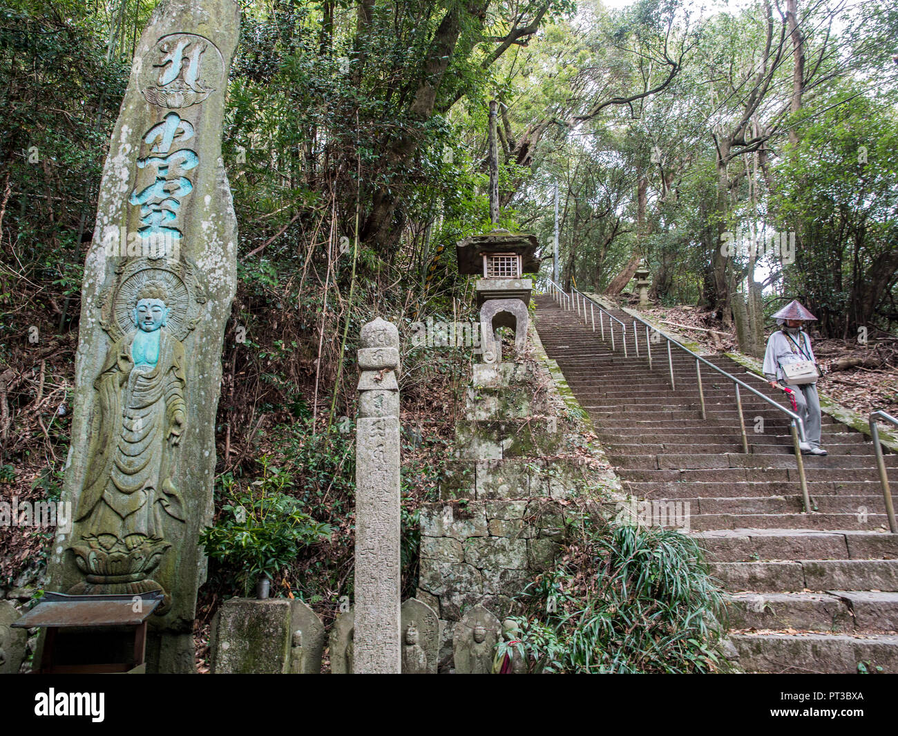 Pilastro di pietra incisa con i kanji e dio buddista e henro pigrim scendendo le scale del tempio, 88 tempio pellegrinaggio di Shikoku Tokushima, Giappone Foto Stock