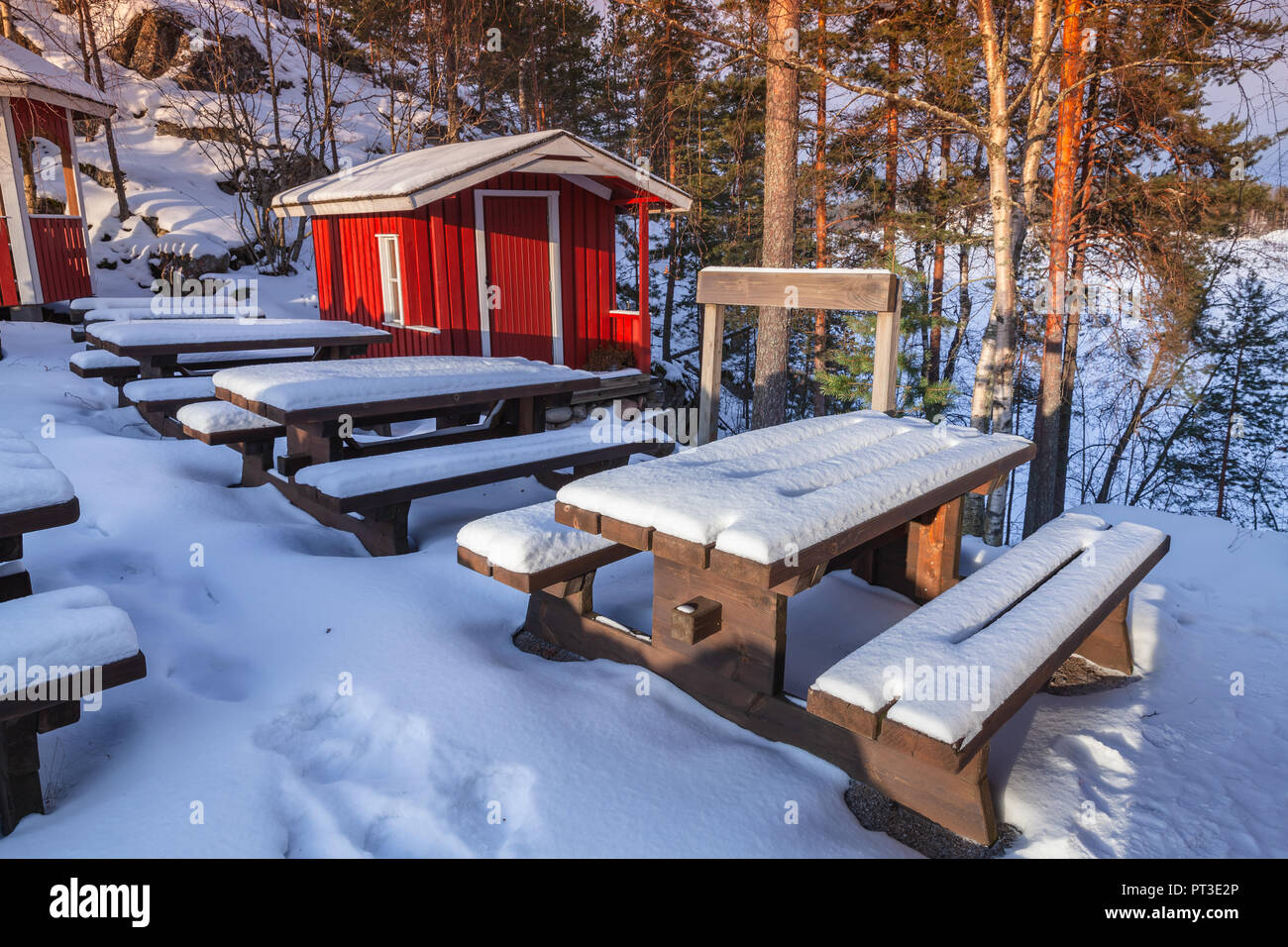 Rurali paesaggio invernale con generic red cottage di legno e mobili da esterno sotto la neve, Finlandia Foto Stock