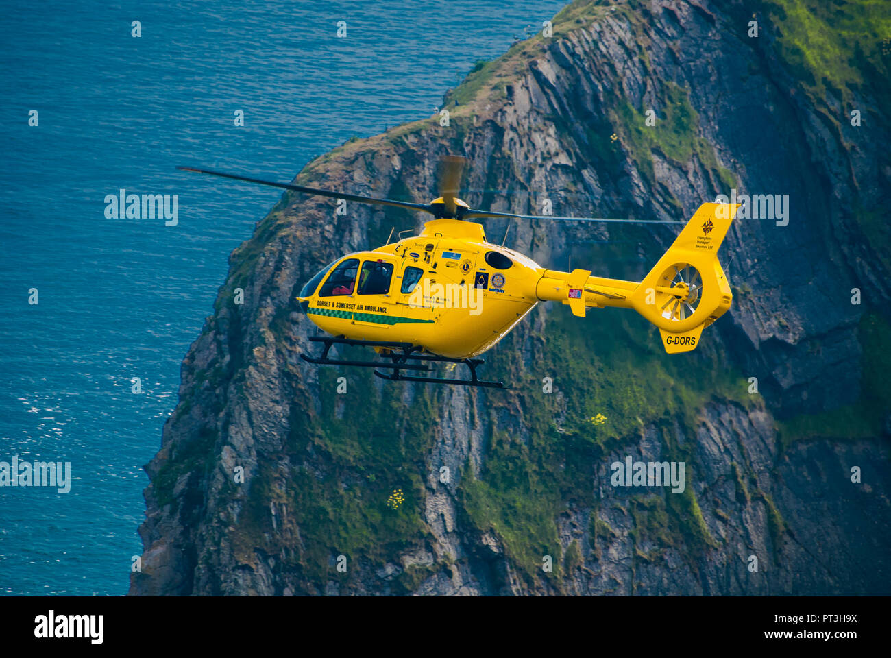 Un Salvataggio in elicottero volando vicino a una parete di roccia in Dorset, Regno Unito. Foto Stock