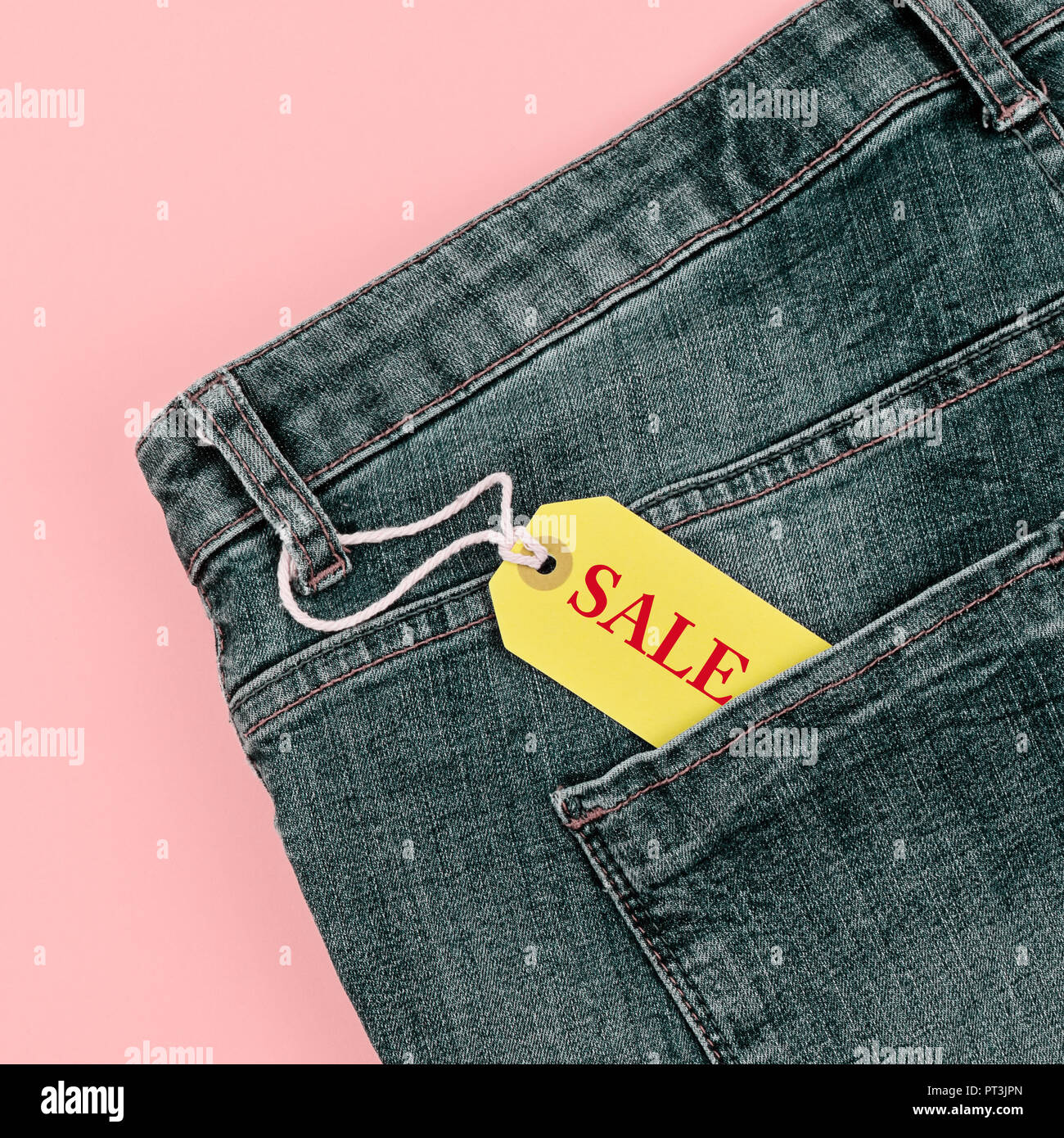 Concetto di vendita Venerdì nero e cyber lunedì sconti tag con jeans blu pastello su sfondo rosa. Spazio di copia, piana, laici formato quadrato Foto Stock