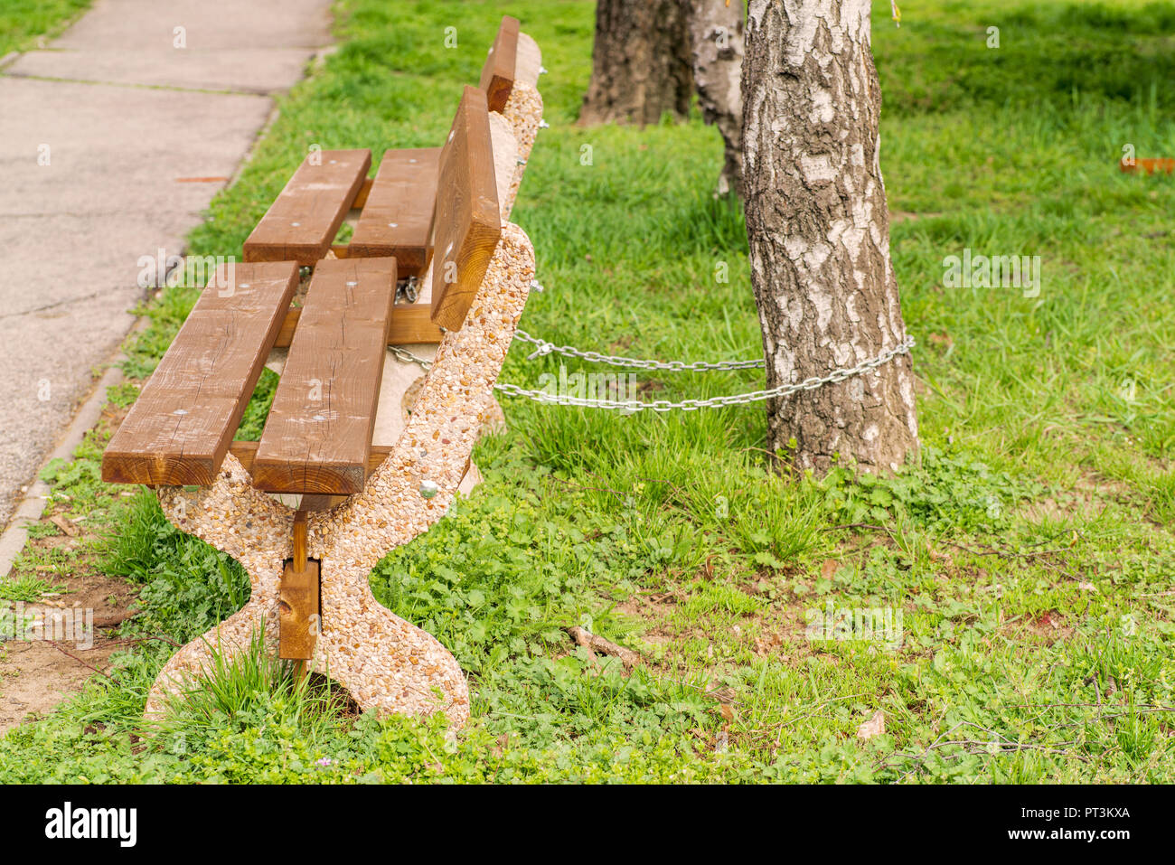 Sedile in legno per la strada con una catena di ferro Foto Stock