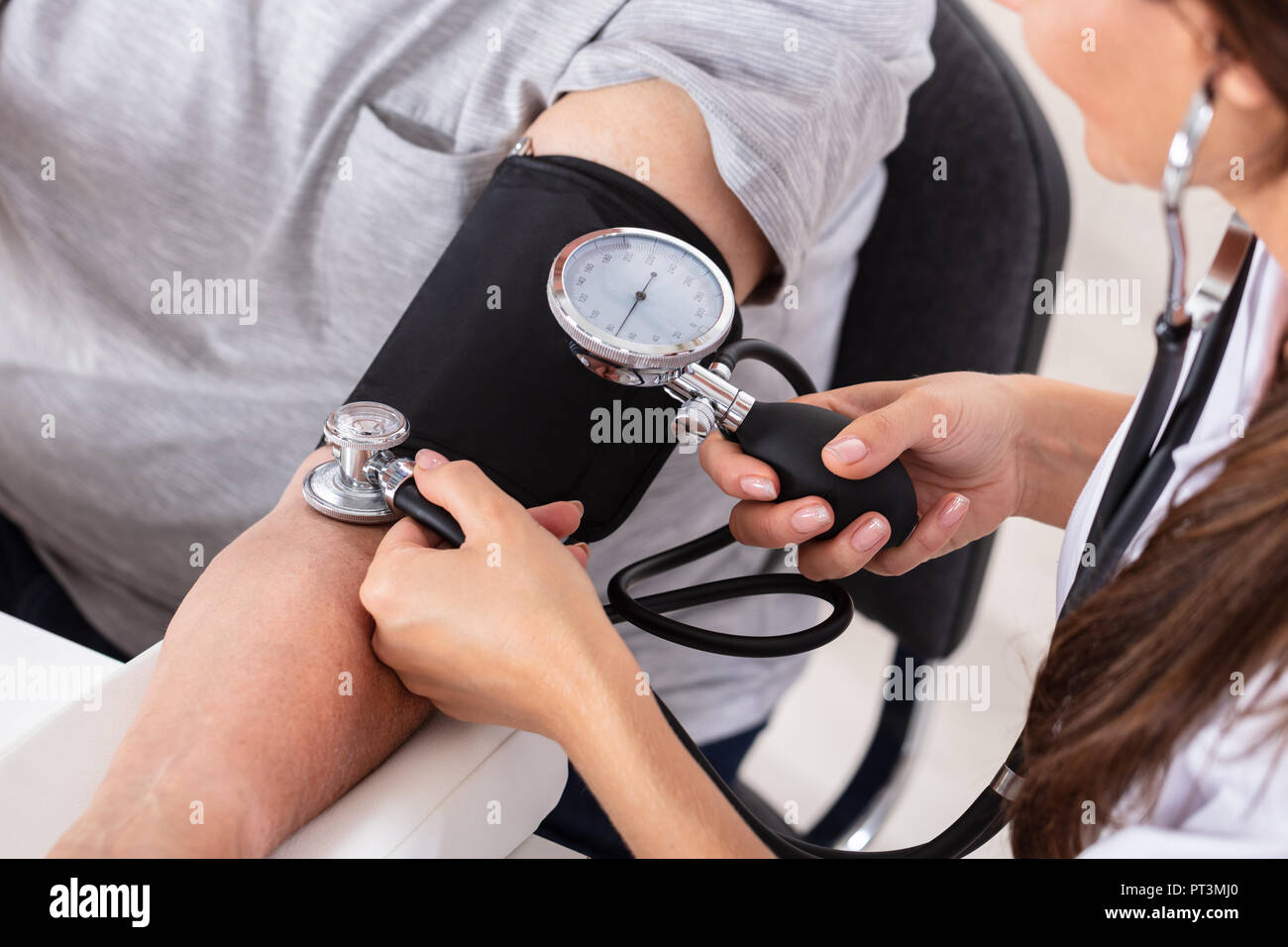 Close-up di un medico di sesso femminile la mano la misura della pressione del sangue del paziente Foto Stock