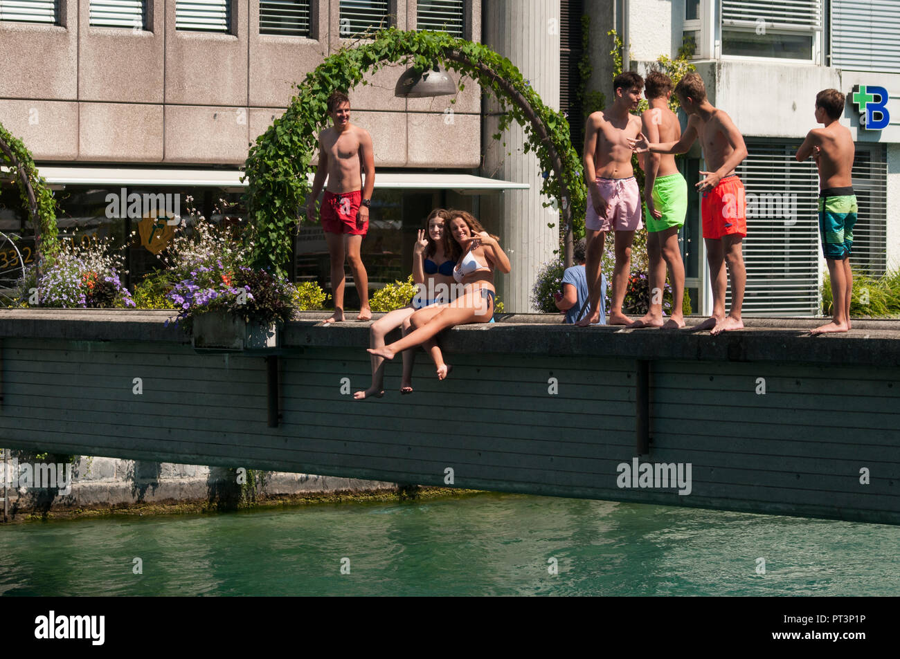 Giovani residenti preparando per tuffarsi nelle acque glaciali del fiume Aare in una calda giornata estiva, a Thun, Svizzera Foto Stock