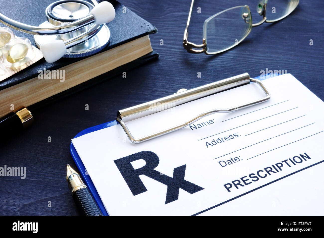 Health care concetto. Modulo di prescrizione e pillole su una scrivania. Foto Stock