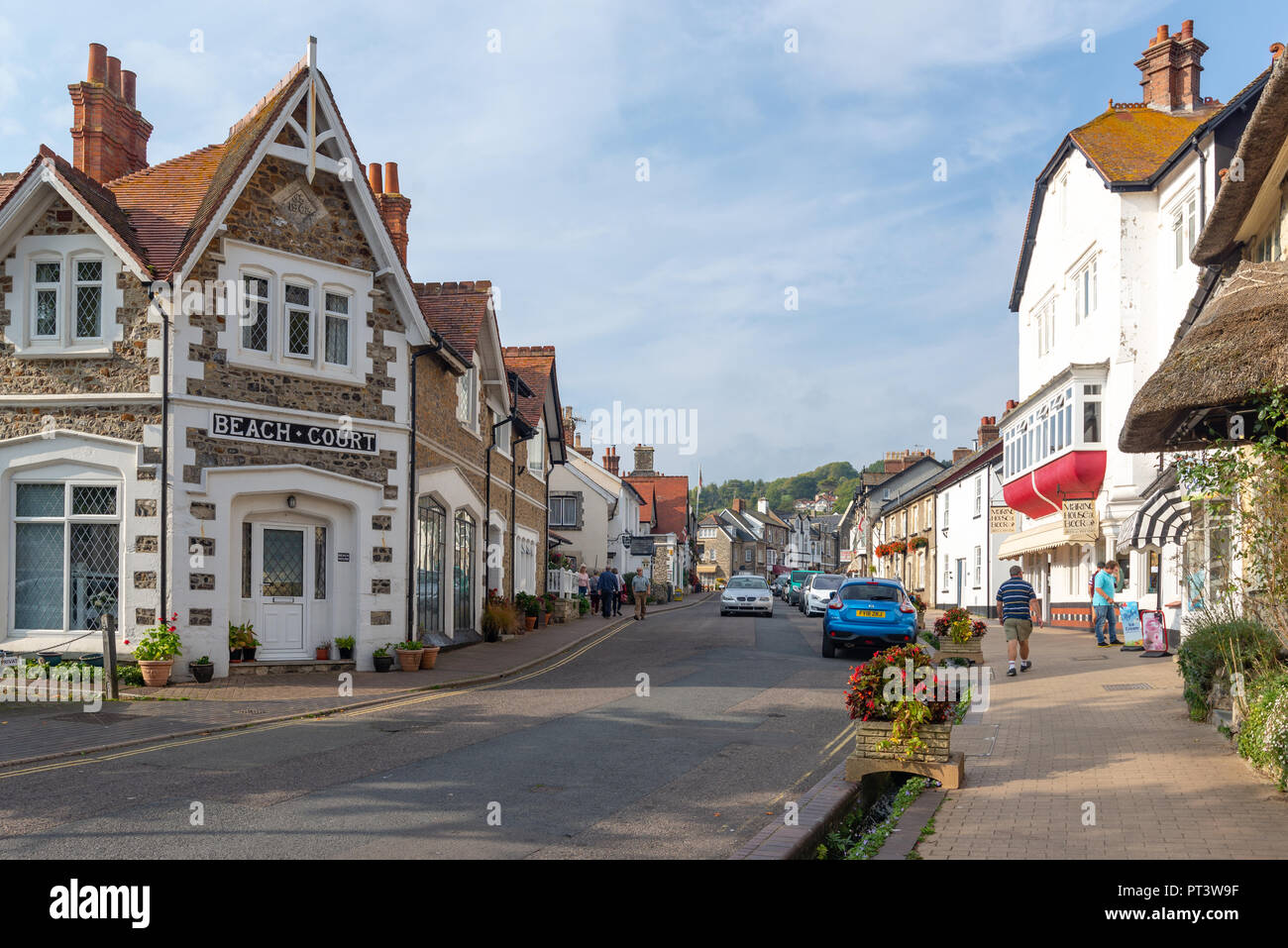 Persone, negozi, ristoranti e aziende su Causeway, high street attraverso la birra, Devon, Inghilterra, Regno Unito Foto Stock